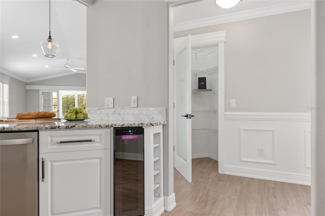 kitchen with wine cooler, white cabinets, ornamental molding, stainless steel dishwasher, and decorative light fixtures