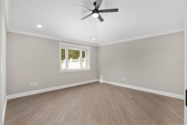 spare room featuring crown molding, light wood finished floors, a ceiling fan, and baseboards