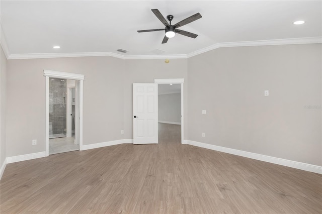 unfurnished room featuring lofted ceiling, light wood finished floors, crown molding, and baseboards