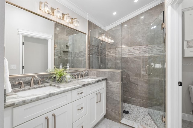 full bath with a shower stall, double vanity, a sink, and crown molding