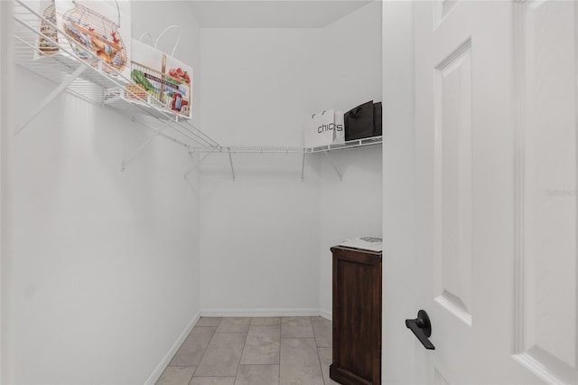 walk in closet with light tile patterned floors