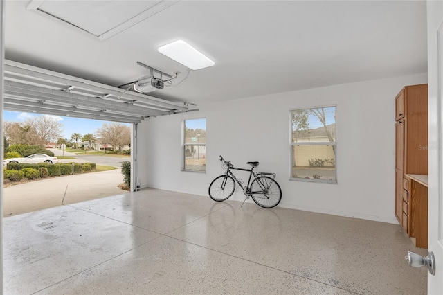 garage featuring a garage door opener and baseboards