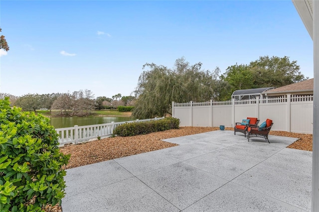 view of patio featuring a water view and a fenced backyard