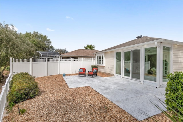 back of house with a fenced backyard and a patio