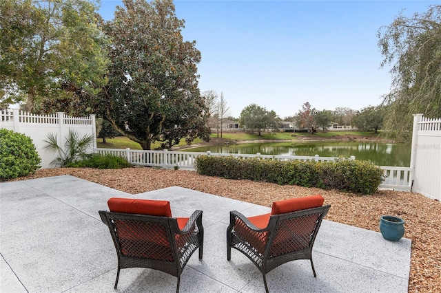 view of patio / terrace with a water view and a fenced backyard