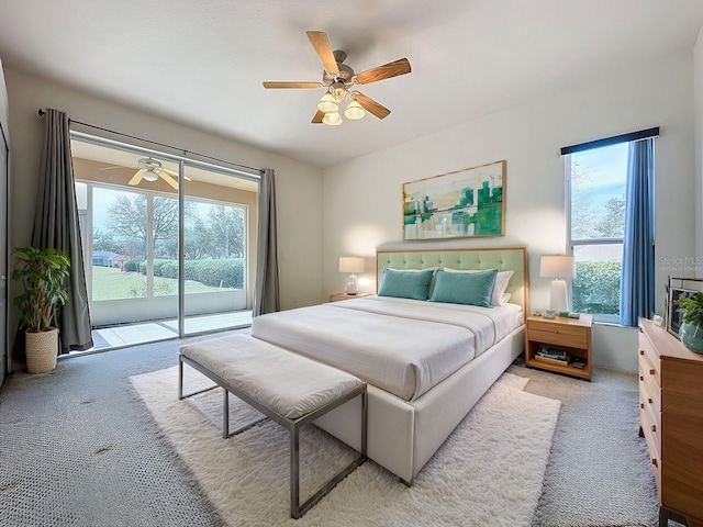 bedroom featuring ceiling fan, access to exterior, light carpet, and multiple windows