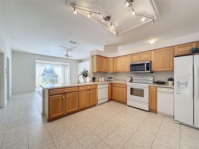 kitchen with sink, light tile patterned floors, white appliances, and kitchen peninsula