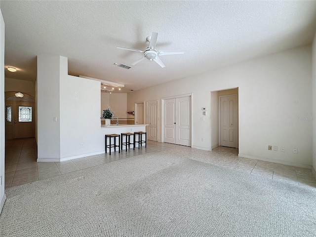 tiled spare room with ceiling fan and a textured ceiling