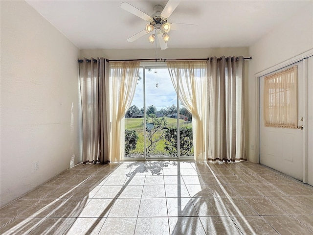 tiled spare room with ceiling fan