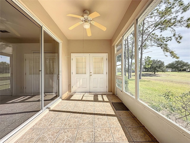 unfurnished sunroom with ceiling fan