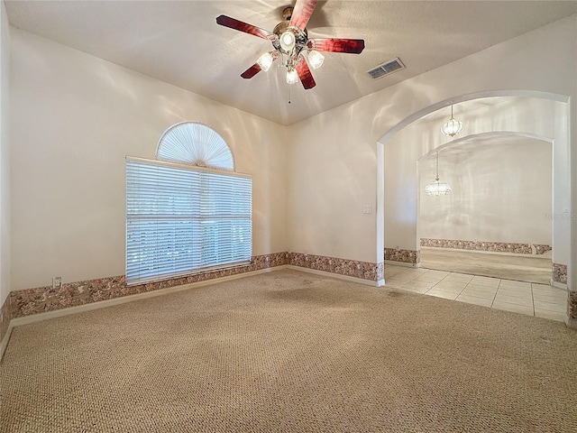 empty room featuring ceiling fan, a textured ceiling, and light tile patterned floors