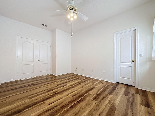 unfurnished bedroom with hardwood / wood-style floors, ceiling fan, and a closet