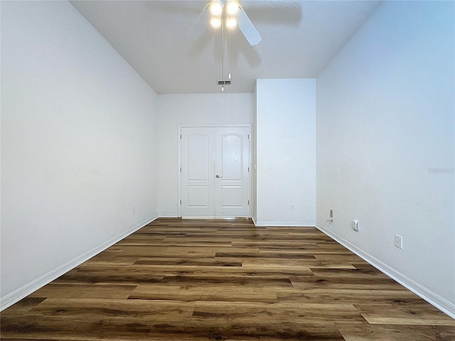 spare room with dark hardwood / wood-style flooring and ceiling fan