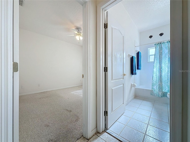 bathroom with tile patterned flooring, ceiling fan, shower / bathtub combination with curtain, and a textured ceiling