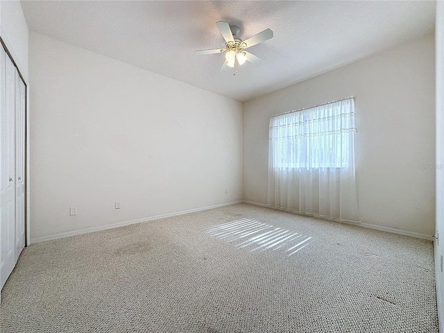 carpeted spare room with ceiling fan