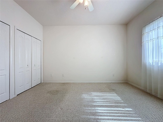 unfurnished bedroom featuring carpet flooring, a textured ceiling, and ceiling fan