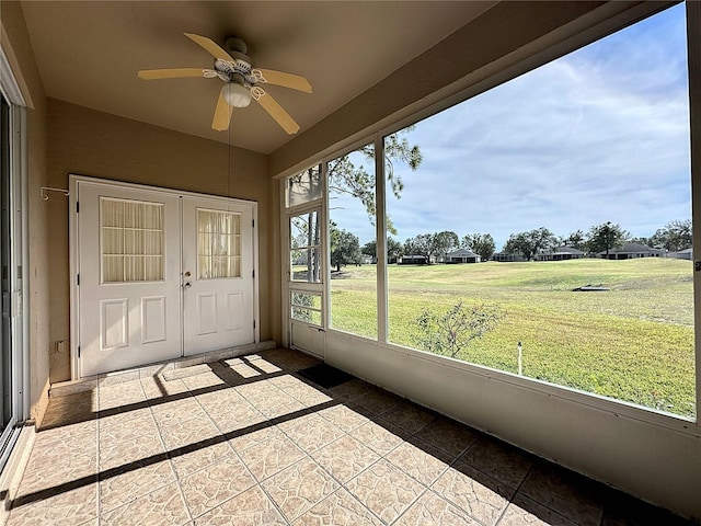 unfurnished sunroom featuring ceiling fan