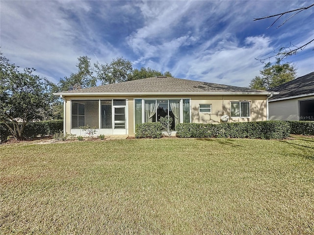 back of house with a sunroom and a lawn