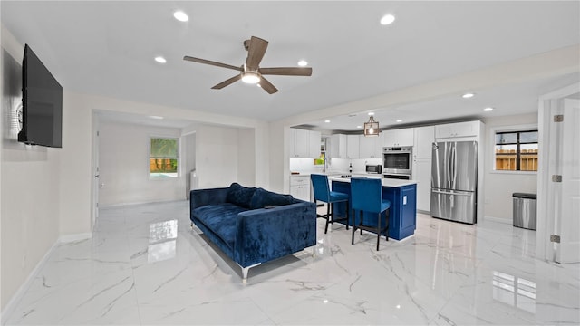 living room with plenty of natural light, sink, and ceiling fan