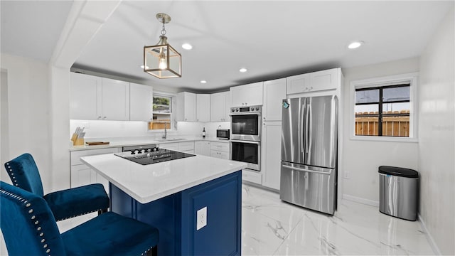 kitchen featuring sink, appliances with stainless steel finishes, a kitchen breakfast bar, a kitchen island, and pendant lighting