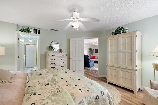 bedroom featuring ceiling fan, light hardwood / wood-style floors, and a textured ceiling