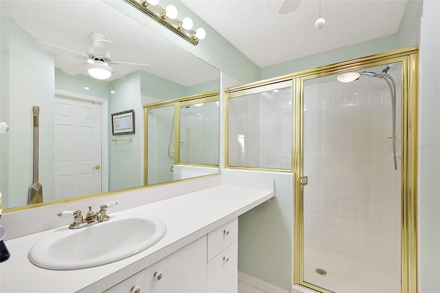 bathroom with ceiling fan, vanity, and a shower with door