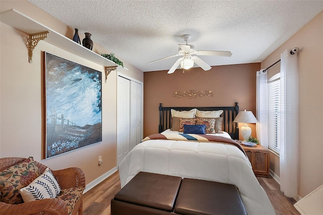 bedroom featuring hardwood / wood-style floors, a textured ceiling, ceiling fan, and a closet