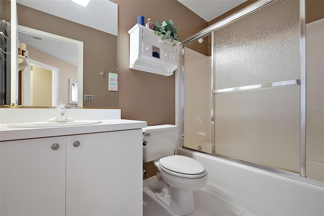 full bathroom with shower / bath combination with glass door, tile patterned flooring, vanity, a textured ceiling, and toilet
