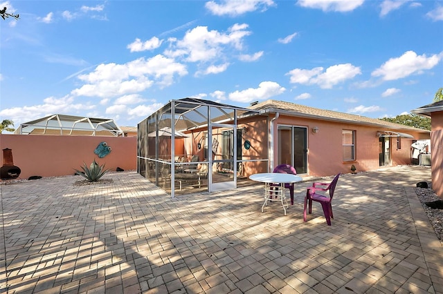 rear view of house with a lanai and a patio
