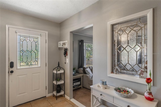 foyer entrance featuring light tile patterned flooring and a textured ceiling