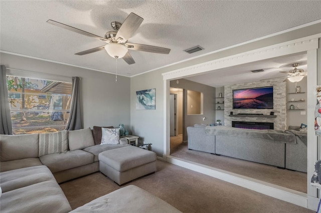 carpeted living room with crown molding, ceiling fan, a fireplace, and a textured ceiling