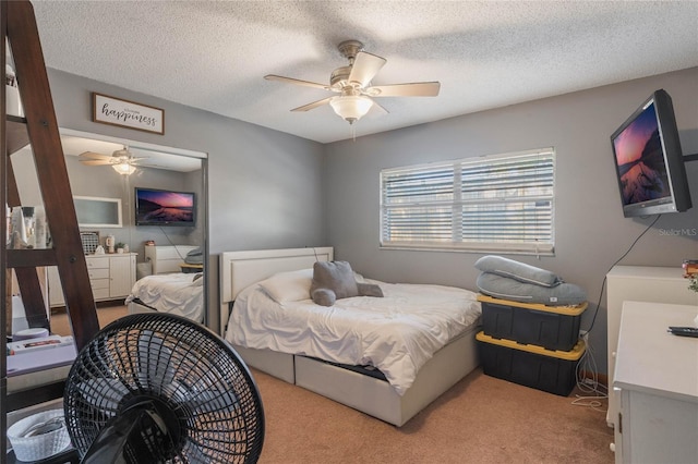 bedroom featuring light colored carpet, a textured ceiling, and ceiling fan