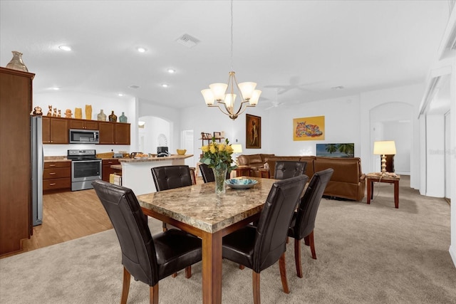 dining area featuring light carpet and a notable chandelier