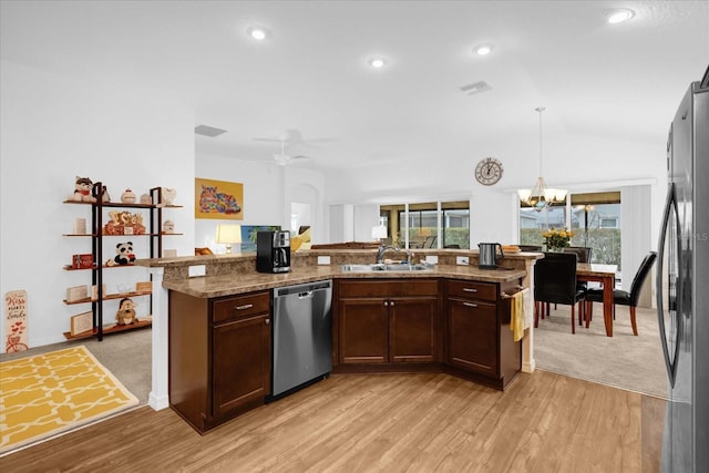 kitchen with sink, hanging light fixtures, stainless steel appliances, light stone countertops, and light wood-type flooring