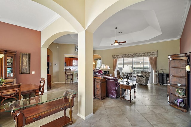 living room with crown molding, a raised ceiling, ceiling fan, and light tile patterned flooring