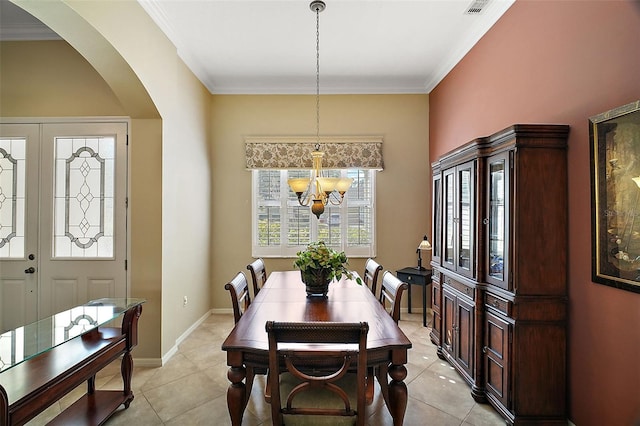 tiled dining area featuring crown molding and a chandelier