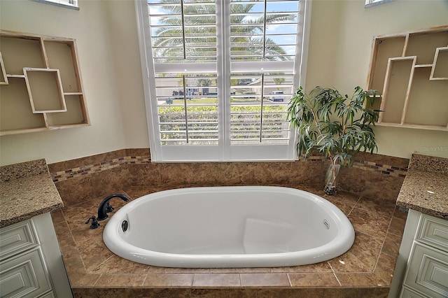 bathroom with vanity and tiled tub