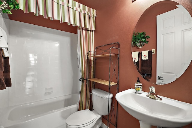 full bathroom with sink, shower / bath combination with curtain, and toilet