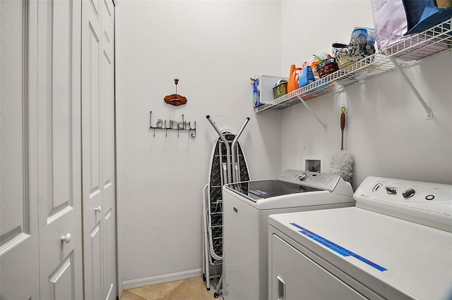 laundry room with independent washer and dryer and light tile patterned flooring