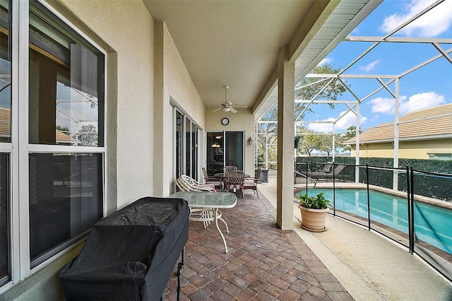 view of patio with ceiling fan, a fenced in pool, and glass enclosure