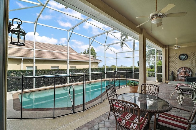 view of swimming pool with ceiling fan, a patio, and glass enclosure