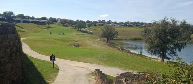 view of property's community with a water view and a yard