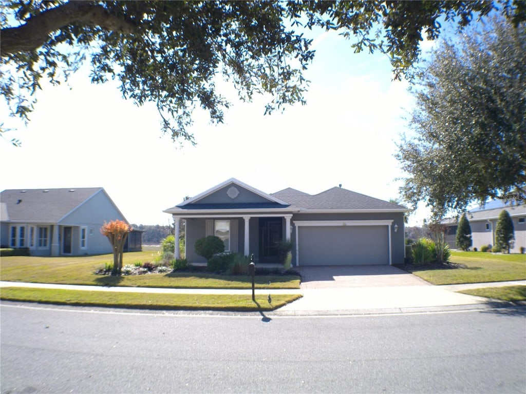 ranch-style home featuring a garage and a front lawn