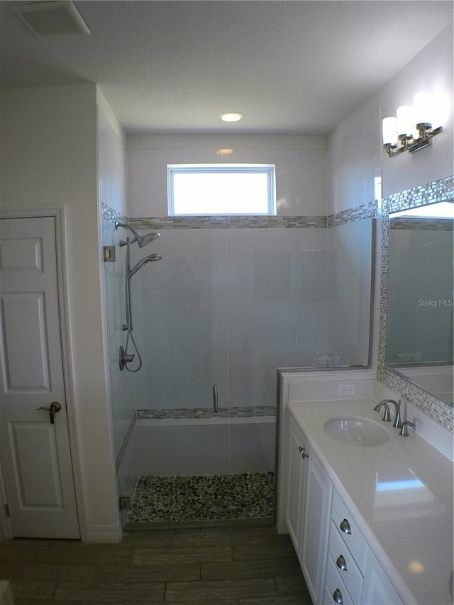 bathroom featuring vanity, wood-type flooring, and a shower with shower door