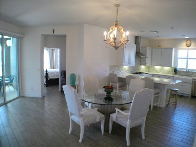 dining room with dark hardwood / wood-style flooring, a chandelier, and sink