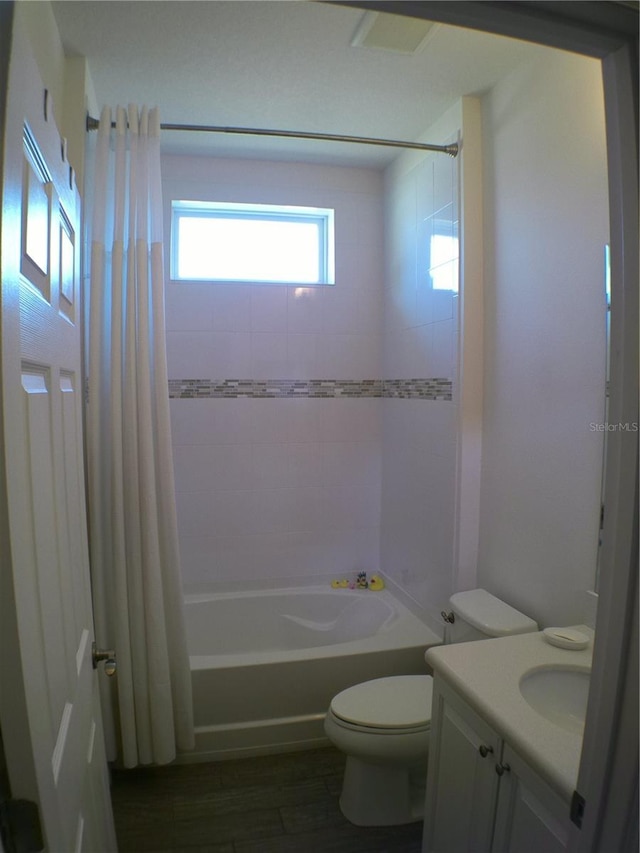 full bathroom with hardwood / wood-style floors, vanity, toilet, and shower / bath combo with shower curtain