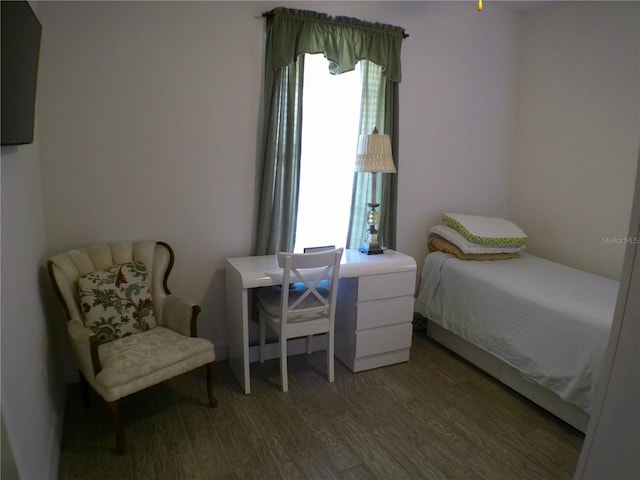 bedroom with multiple windows and wood-type flooring