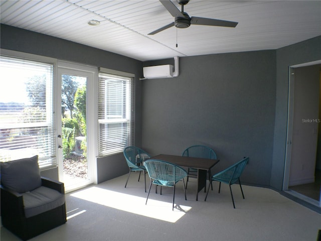 sunroom featuring a wealth of natural light, an AC wall unit, and ceiling fan