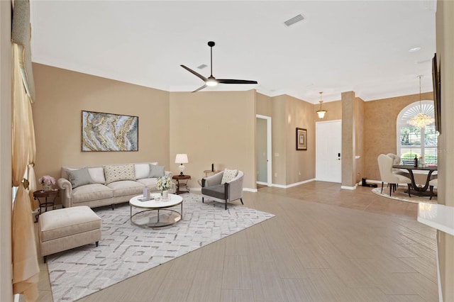 living room featuring crown molding, ceiling fan, and light hardwood / wood-style flooring