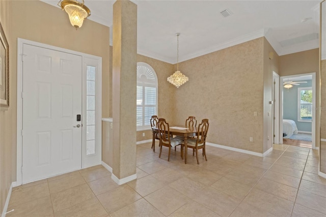 entrance foyer with crown molding, a chandelier, and light tile patterned floors